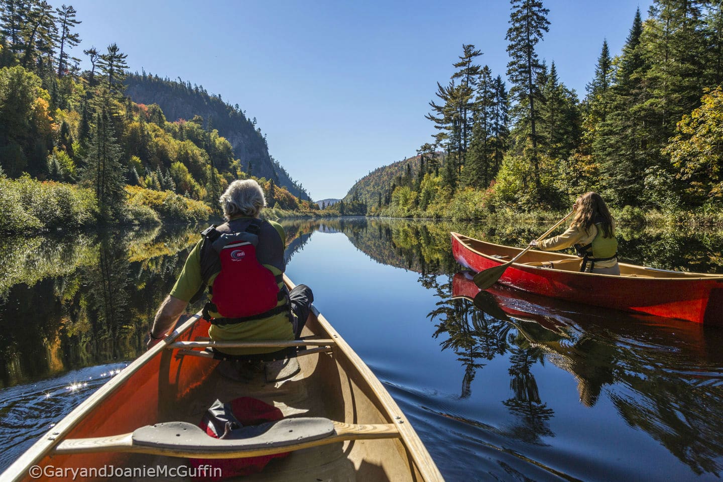 Two people canoeing on calm river in Northern Ontario