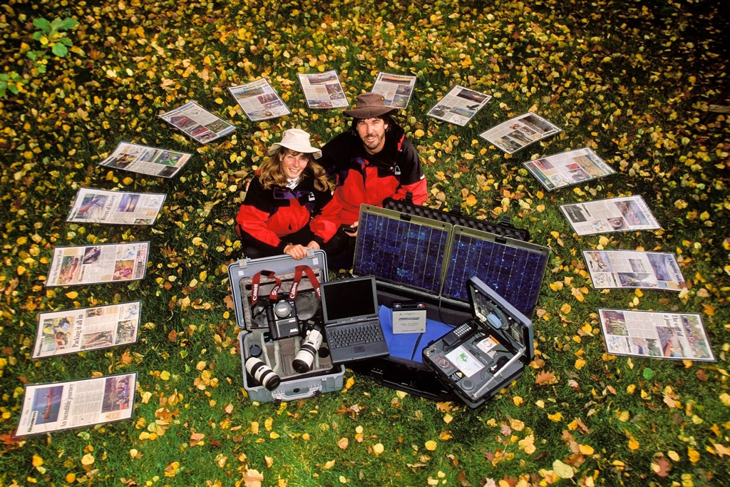 Outdoor adventure couple with equipment and newspaper articles